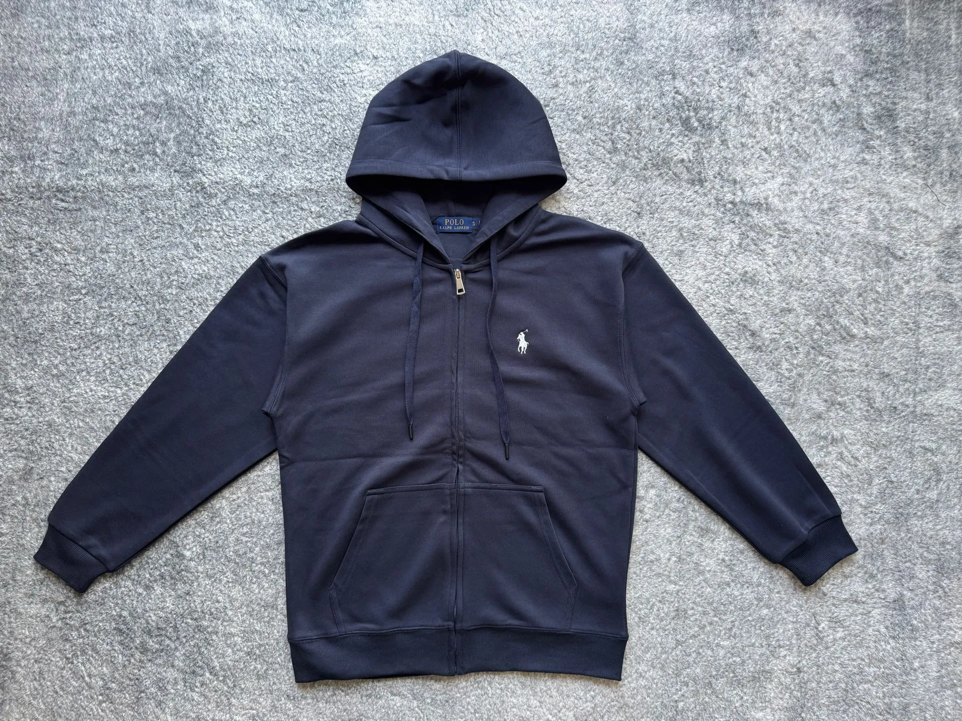 P186 Polo Ralph Lauren SS22 classic solid color logo embroidered long-sleeved hooded sweatshirt. This hooded zipper sweatshirt has outer seam design as the highlight. The details are interesting but not too high-profile. The black bottom is paired with a silver zipper. The overall look is low-key and neat, and the texture is very online. The version is relatively loose, making it very comfortable to wear. The style is more relaxed and does not pick on people or occasions. It looks very stylish when worn alone, and it’s totally OK when paired with a T-shirt. It is versatile when paired with jeans or khakis. It is casual and not sloppy. It can be easily used for commuting, parties and daily life. It is the kind of item that is often worn in the wardrobe but is reluctant to change. Color: Black Gray Navy Size Clothes length Shoulder width Bust Sleeve length Recommended weight S 69 56 54 54 115-130 M 71 59 57 55 130-155 L 73 62 60 56 155-175 XL 75 65 63 57 175-200